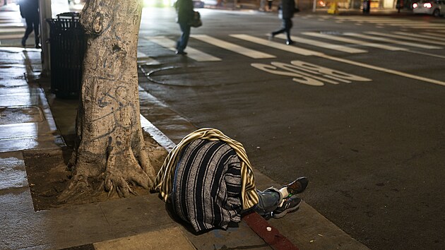 Bezdomovec spc na chodnku v Los Angeles (14. prosince 2022)
