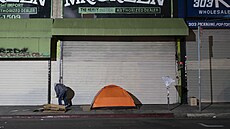 Mu bez domova stojí vedle svého stanu v Los Angeles. (14. prosince 2022)