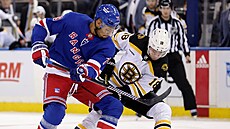 Pavel Zacha (18) z Boston Bruins a K'Andre Miller z New York Rangers bojují o...