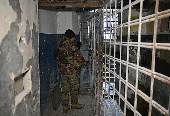 Ukrajinský voják v Chersonu prochází suterénem policejního editelství, které...