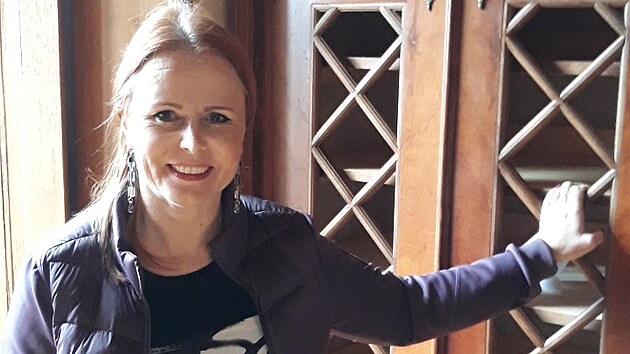 Miroslava Poskočilová, ředitelka děčínského zámku, u prázdné knihovny, kde knihy Thunů byly ve dvou řadách.