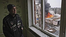 Obyvatel msta asiv Jar pozoruje kou z hoící domu, který byl zasaen ruskými...