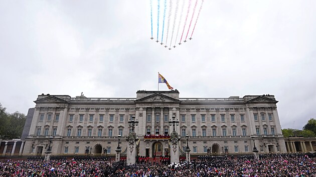 Britsk krl Karel III. a krlovna Camilla na balkon Buckinghamskho palce sleduj pelet letoun Royal Air Force Red Arrows po korunovanm obadu v Londn. (6. kvtna 2023)