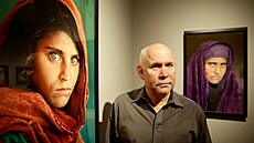 Americký fotograf Steve McCurry pózuje vedle svých fotografií "afghánské dívky"...