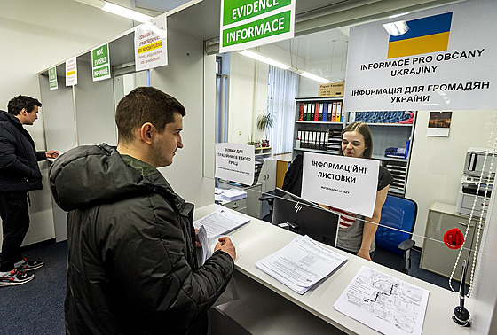 Ukrajinci pebírají formuláe a informaní letáky na pepáce úadu práce.
