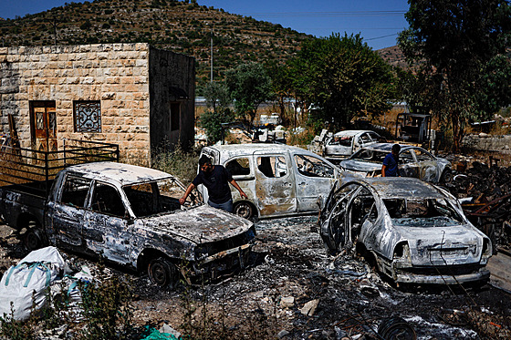 Palestinci kontrolují spálená vozidla po útoku izraelských osadník poblí...