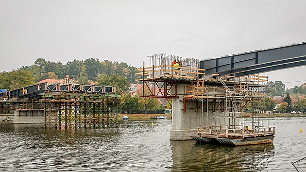 Z původního mostu zbyly jen pilíře. Na ty teď dělníci připevňují nové nosníky.