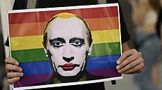 Osoba drí duhový plakát s vyobrazením ruského prezidenta Vladimira Putina...
