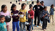 Vysídlené palestinské dti ekají na bezplatné jídlo ve stanovém táboe v...