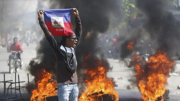 Demonstrant dr haitskou vlajku bhem protest poadujcch odstoupen premira Ariela Henryho v Port-au-Prince. (2. bezna 2024)