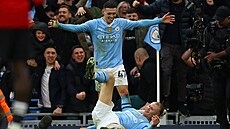 Kanonýr Erling Haaland z Manchesteru City (na zemi) slaví svj gól s Philem...