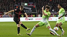 Útoník Leverkusenu Patrik Schick stílí skrz hráe Wolfsburgu Kevina Paredese...