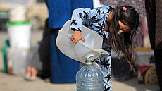 Palestinská dívka si pelévá svj díl pitné vody, který dostala ve mst Rafáh...