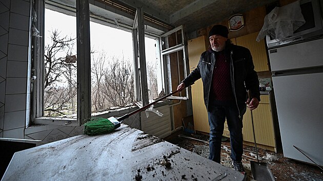 Mstn obyvatel odstrauje trosky ze svho bytu pokozenho ruskm raketovm tokem v Zporo. (22. bezna 2024)