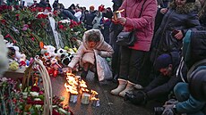 Rusové nosí na pietní místa kvtiny, plyáky a  zapalují svíky. (23. bezna...