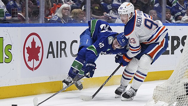 Ryan Nugent-Hopkins (vpravo) z Edmontonu brání Quinna Hughese z Vancouveru.