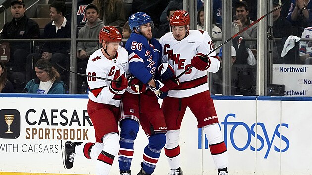 Martin Nečas (vlevo) a Brady Skiel z Caroliny brání Willa Cuylleho z New York Rangers.