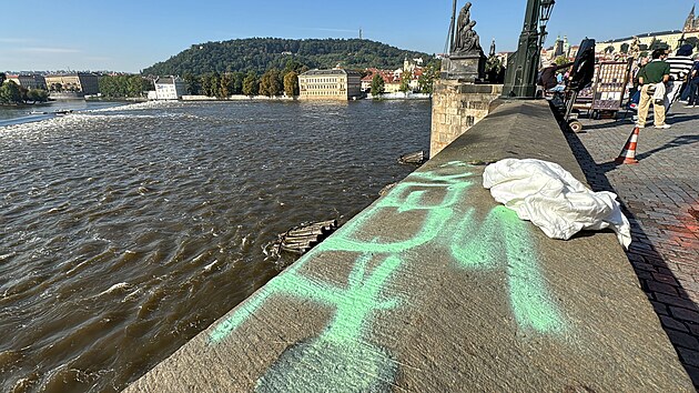 Na Karlově mostě se objevil zeleně nasprejovaný nápis. Pražské služby se ho nyní pokouší odstranit. (20. září 2024)