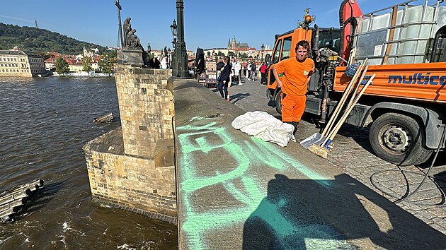 Na Karlově mostě se objevil zeleně nasprejovaný nápis. Pražské služby se ho nyní pokouší odstranit. (20. září 2024)