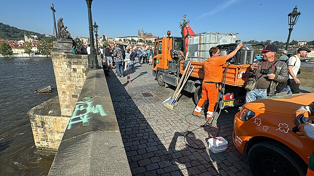 Na Karlově mostě se objevil zeleně nasprejovaný nápis. Pražské služby se ho nyní pokouší odstranit. (20. září 2024)
