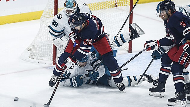 Obránce Jan Rutta ze San Jose Sharks padá na led po souboji s Ninem Niederreiterem z Winnipeg Jets.