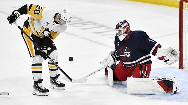 Brankář Eric Comrie z Winnipegu čelí šanci Larse Ellera z Pittbsurghu.