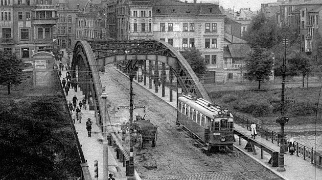 Říšský most přes Ostravici (dnes most Miloše Sýkory) s motorovým vozem jedoucím do Michálkovic kolem roku 1927. Trať SZD byla z Polské Ostravy do Moravské Ostravy prodloužena v roce 1917. GPS: 49.8375644N, 18.2965667E