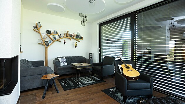 Kytara pána domu nesmí chybět, stejně jako dekorace v podobě stromu na stěně s fotografiemi.