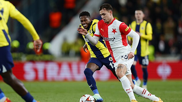 Slávistický křídelník Matěj Jurásek vede míč mezi hráči Fenerbahce.