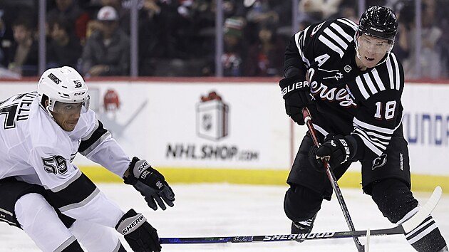 Ondřej Palát (18) z New Jersey Devils přihrává v zápase s Los Angeles Kings kolem Quintona Byfielda (55).