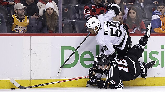 Ondřej Palát (18) z New Jersey Devils a Quinton Byfield (55) z Los Angeles Kings bojují u mantinelu.