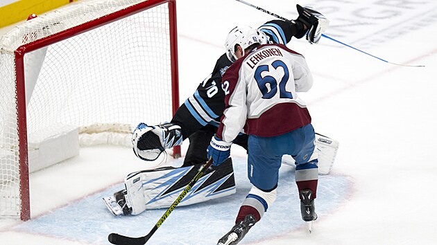 Artturi Lehkonen se snaží zasunout kotouč za Karla Vejmelku.