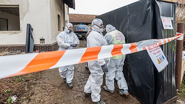 Technici v ochranných oblecích demontují azbestovou krytinu před demolicí domů, které ve Všestarech na Hradecku ustoupí dálnici D35 (7.1.2025).
