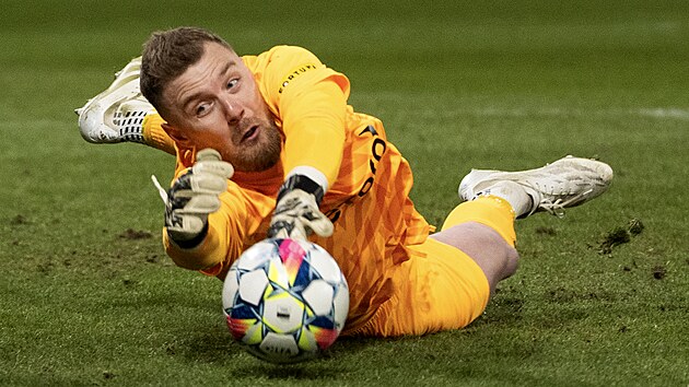 Brank&aacute;ř Slavie Jindřich Staněk se natahuje po balonu.