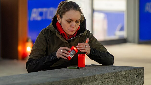 Lidé zapalují svíčky u prodejny v Hradci Králové, kde mladík ubodal dvě prodavačky (20. 2. 2025).