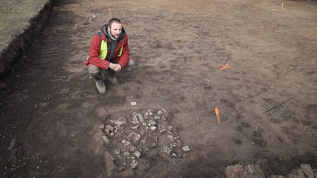 Archeolog Slezského zemského muzea Ondřej Klápa u odkryté ploštěnky, která sloužila k přípravě pokrmů pomocí horkých kamenů v jámě. (3. března 2025)