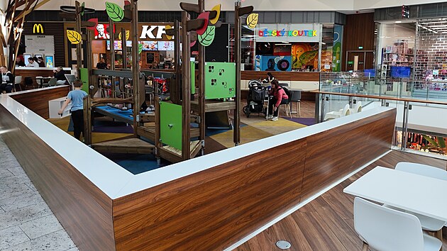 Dítě vylezlo na zídku oddělující dětskou část jídelní zóny od zbytku prostoru.