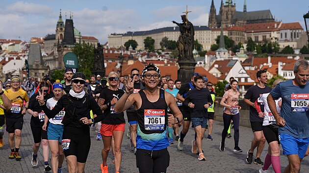 Běžci si už&iacute;vaj&iacute; Pražsk&yacute; maraton. Pr&aacute;vě přeb&iacute;haj&iacute; Karlův most.