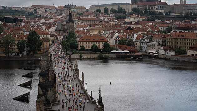 Pohled na Pražsk&yacute; maraton. Běžci překon&aacute;vaj&iacute; Karlův most.