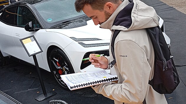 Špioni přeměřují auta vystavená na autosalonu v Mnichově.