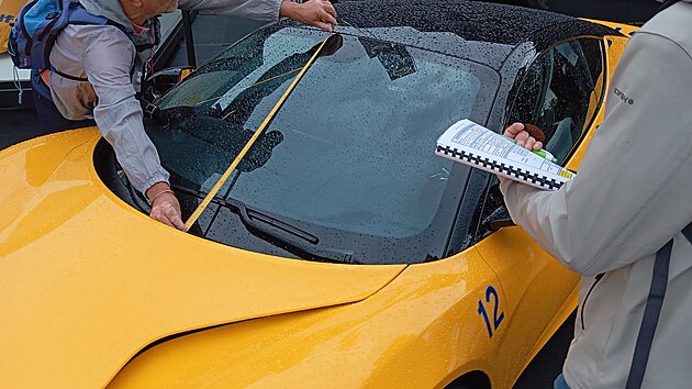 Špioni přeměřují auta vystavená na autosalonu v Mnichově.