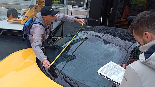 Špioni přeměřují auta vystavená na autosalonu v Mnichově.