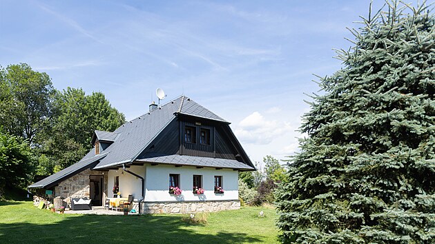 Chalupa na první dobrou působí starším dojmem. Postavená ovšem byla teprve před dvaceti lety a do okolní krajiny hezky zapadla.