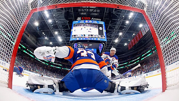 Brankář David Rittich z New York Islanders zasahuje proti Connoru McDavidovi z Edmontonu.