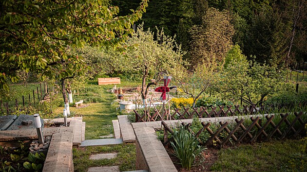 Pohled přes páteřní schodiště a terasy se záhony dolů k potoku – tedy do sadu a k zeleninovým záhonům.