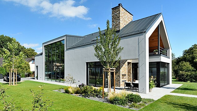 Vizuálně nejvýraznější prvek exteriéru domu představuje velkoformátová fixní okenní stěna s integrovanými prosklenými dveřmi, která umožnila vpustit světlo do celé chodby v obou patrech.