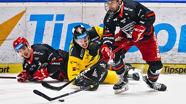 Litvínovský Marek Baránek se vleže sápe po puku, který drží Denis Kusý z Hradce Králové. Přihlíží Jordan Perret.