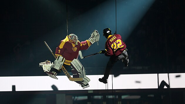 Pod střechou Horácké arény v Jihlavě se zavěšeni na lanech vznášejí živí hokejisté.