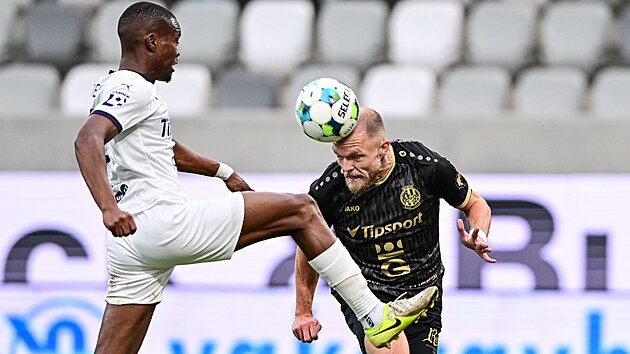 Útočník Mick van Buren z Hradce Králové hlavičkuje před Giglim Ndefem ze...