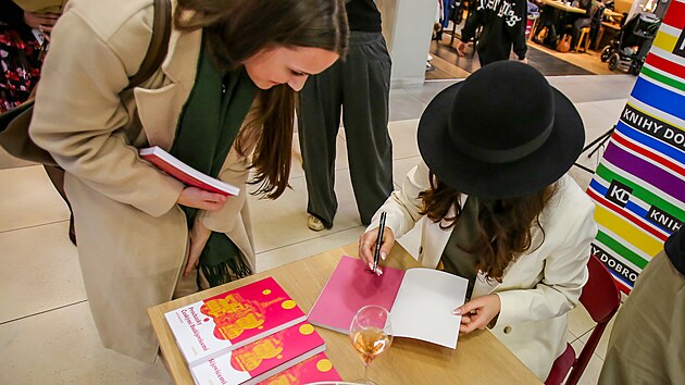 Budějčanda píše věnováním zájemcům o knihu.